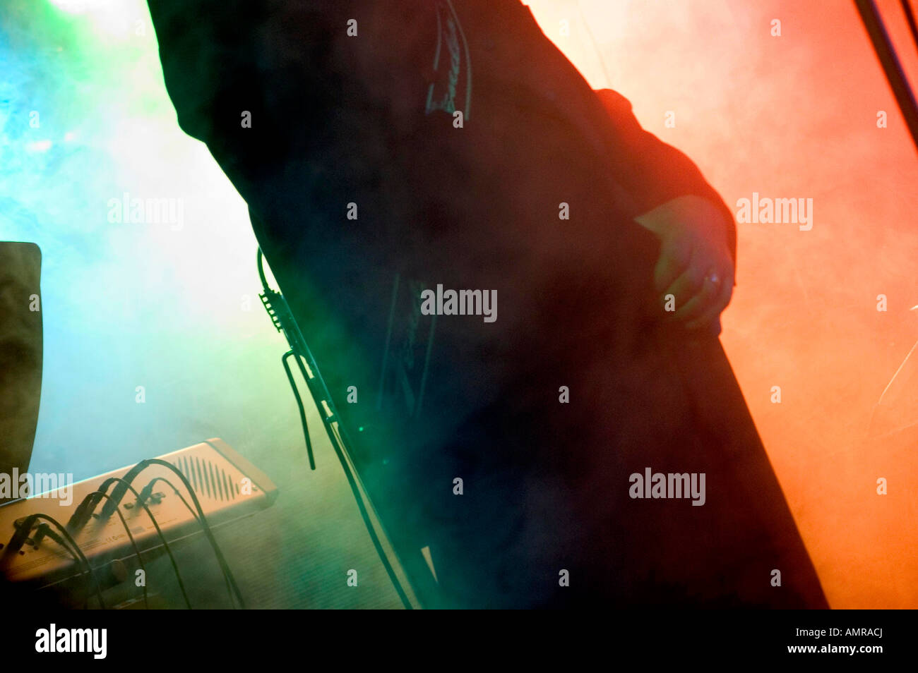 Il chitarrista esibirsi sul palco con fumo e colorata illuminazione posteriore Foto Stock