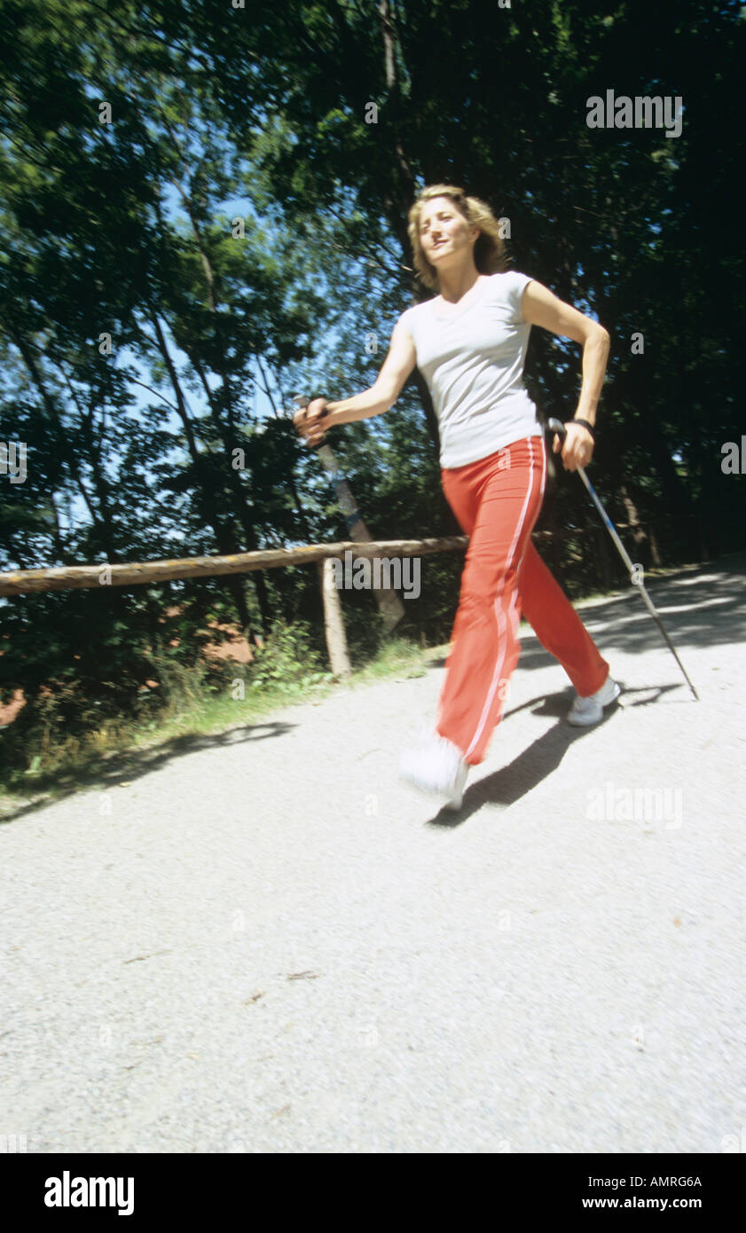 Donna che cammina con bastoni, nordic walking Foto Stock