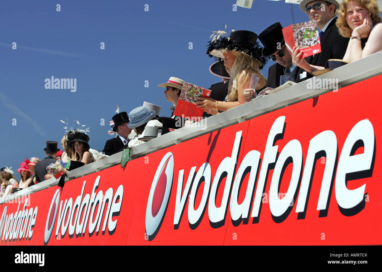 Di spettatori e un cartellone pubblicitario di Vodafone a corse di cavalli in Epsom, Gran Bretagna Foto Stock