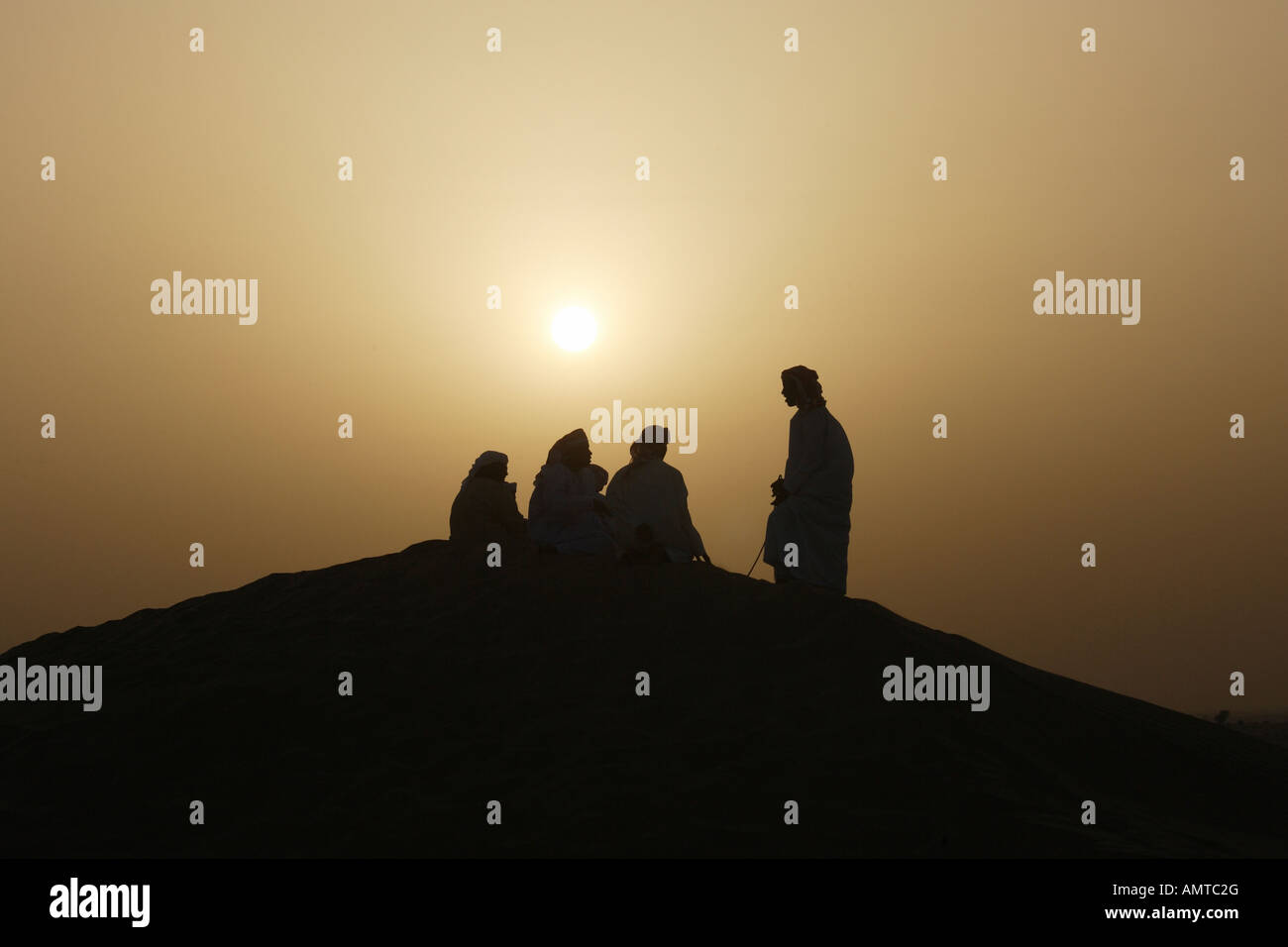 Gli uomini arabi nel deserto al tramonto Foto Stock