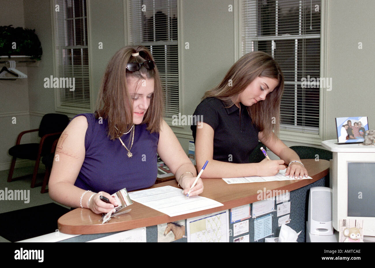 Due richiedenti lavoro uno vestito in modo appropriato uno non compilare una richiesta di lavoro per una nuova intervista di lavoro Foto Stock