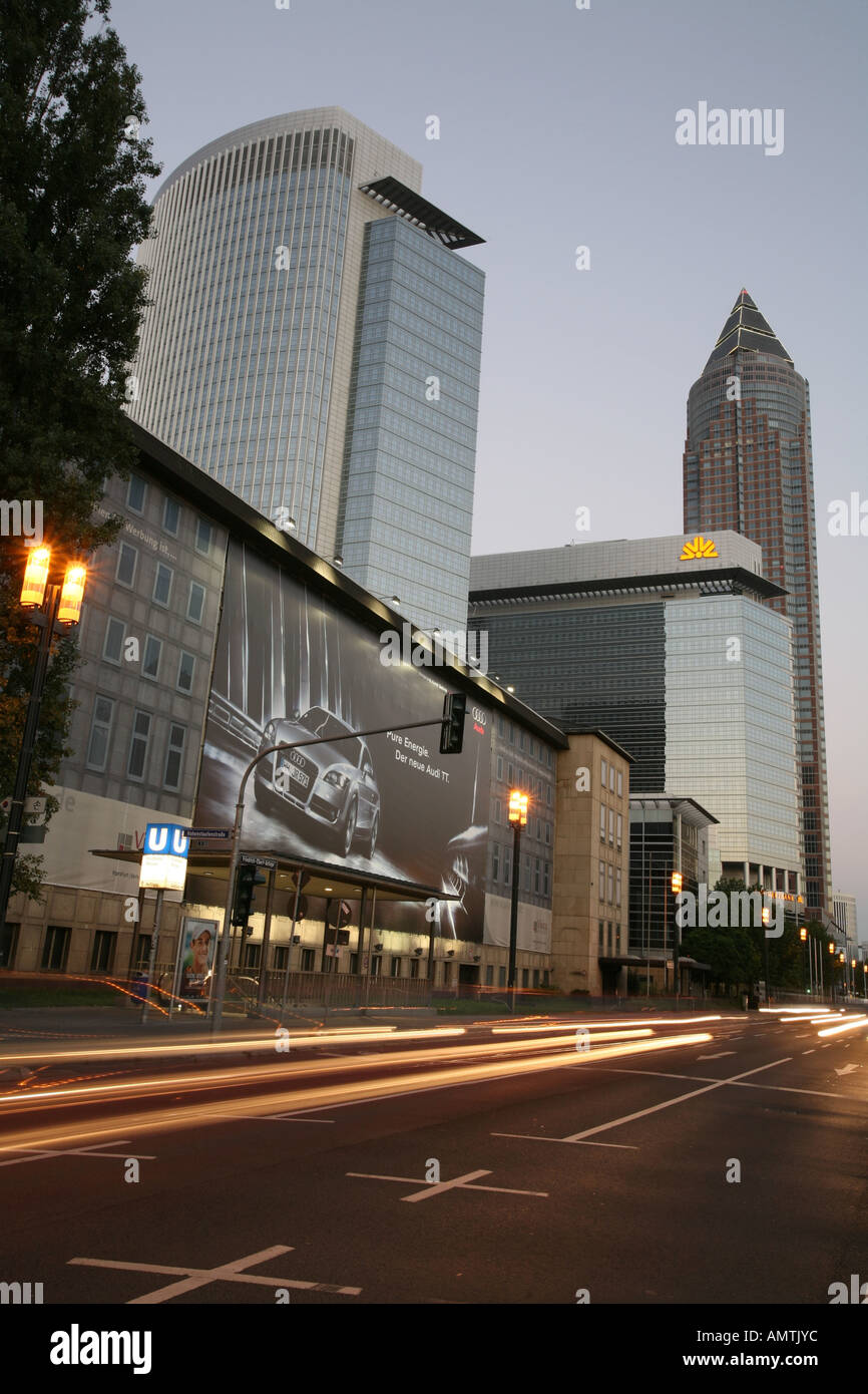 Torre della Commerzbank e la fiera con grande pubblicità e le luci di passaggio di vetture al crepuscolo, Frankfurt/Main, Hessen, Germania Foto Stock