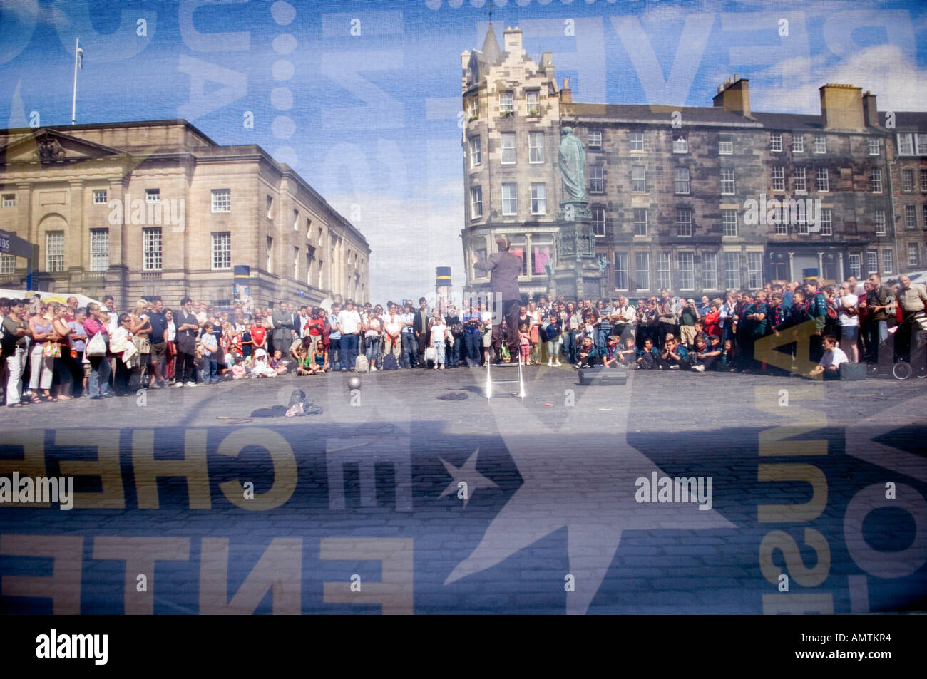 Spettacolo di strada visto attraverso un banner del Edinburgh Fringe Festival Foto Stock