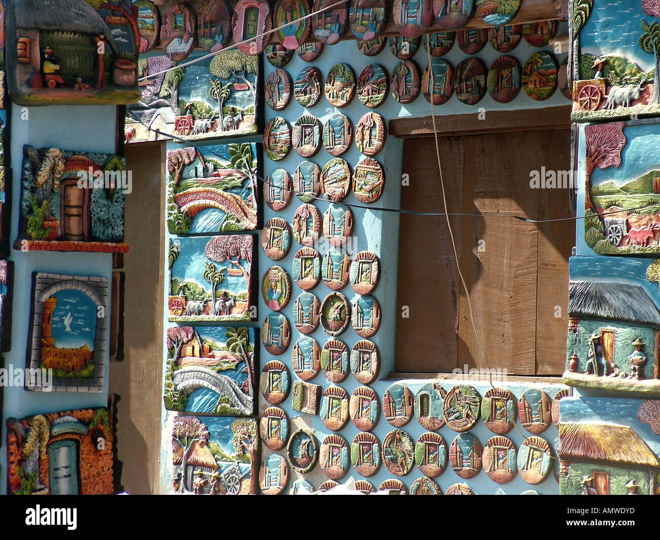 Sovraffollamento parete espositiva di colorati e trashy di piastre e le foto presso il villaggio di arte, Aregua vicino ad Asunción, Paraguay Foto Stock