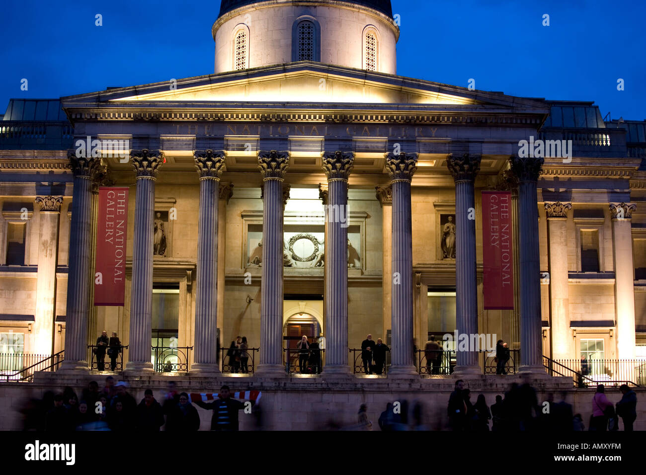 I turisti di fronte all edificio accesa fino al crepuscolo, National Gallery, Trafalgar Square, Westminster, Londra, Inghilterra Foto Stock