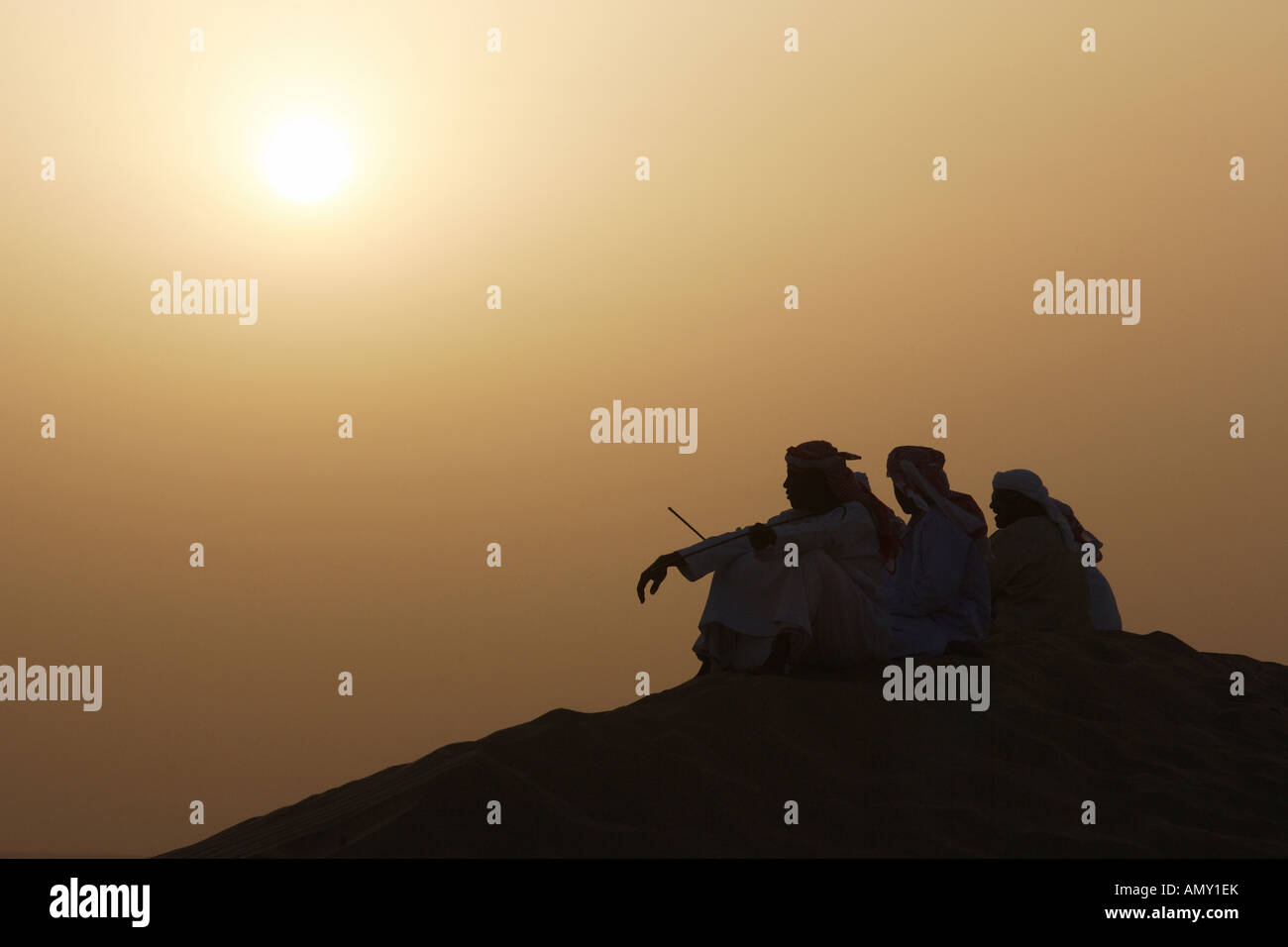 Gli uomini arabi nel deserto al tramonto Foto Stock