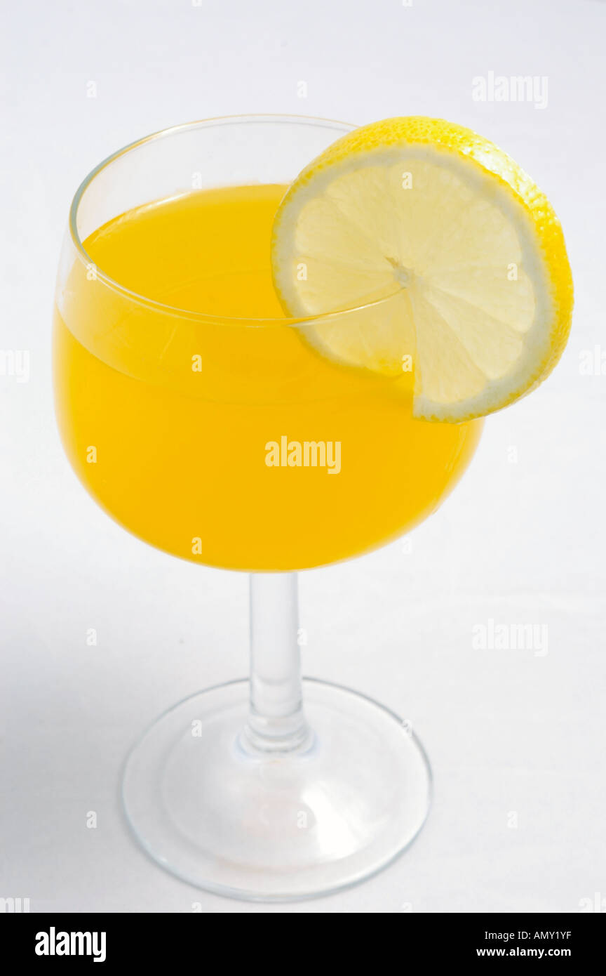 Un bicchiere di succo di arancia con una fetta di limone su sfondo bianco Foto Stock