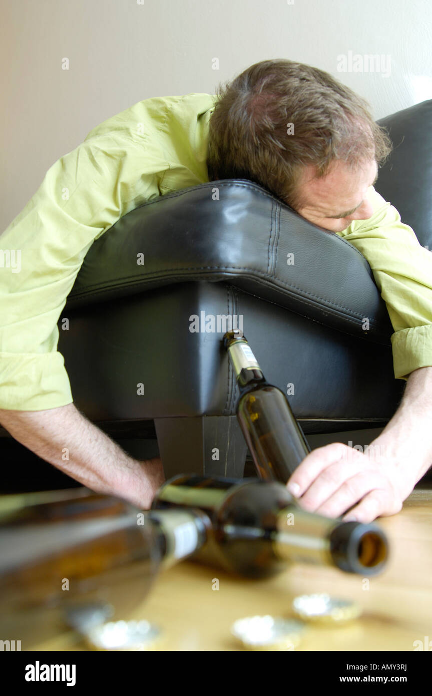 Ubriaco sdraiato sul divano Foto Stock