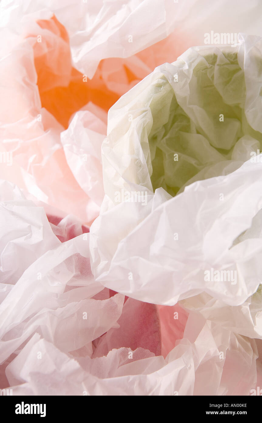 Set di cartapesta multi-colore di bocce, avvolto in carta velina bianca per un regalo. Girato su uno sfondo bianco. Foto Stock