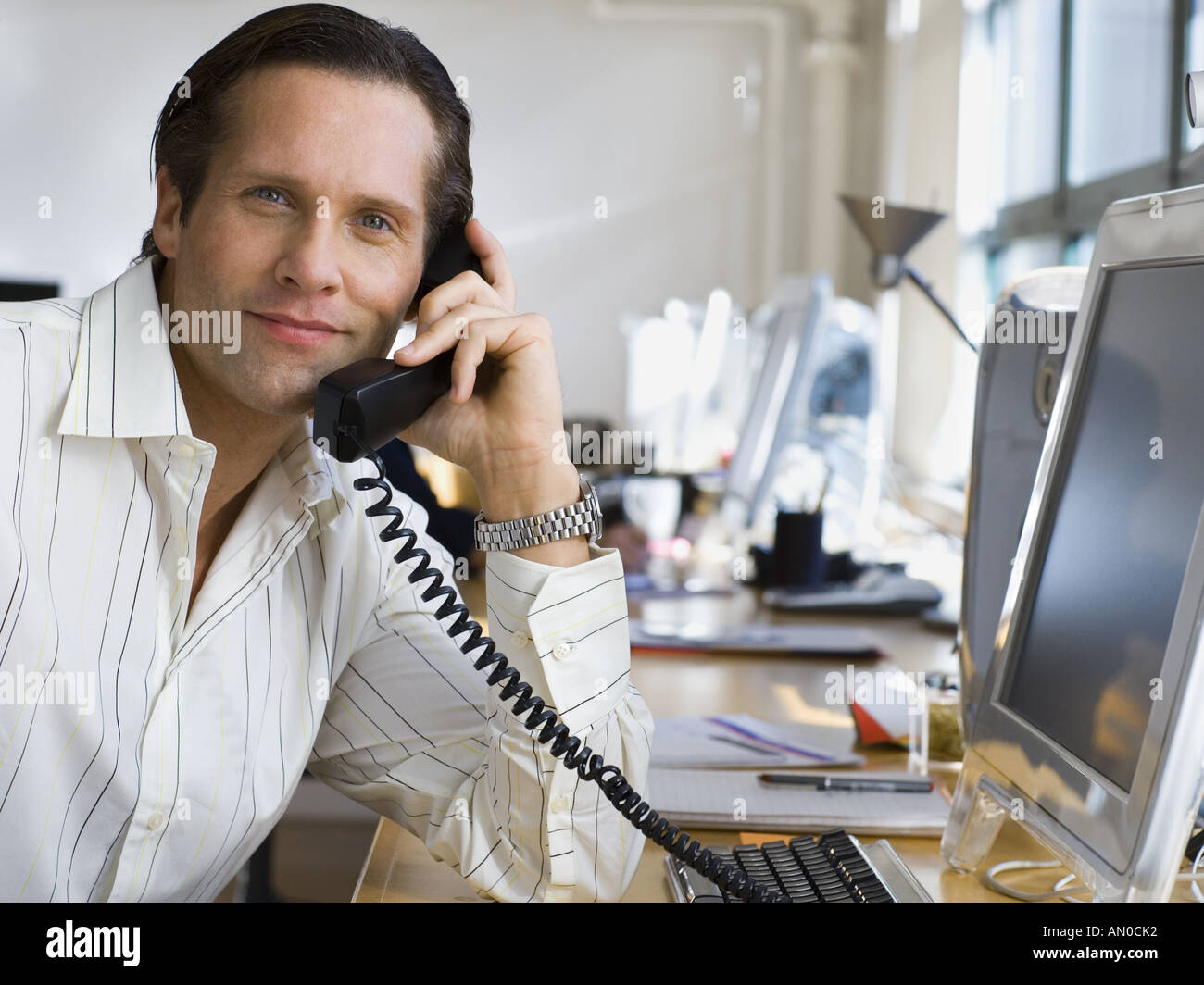 Ritratto di una metà uomo adulto parlando al telefono in un ufficio Foto Stock