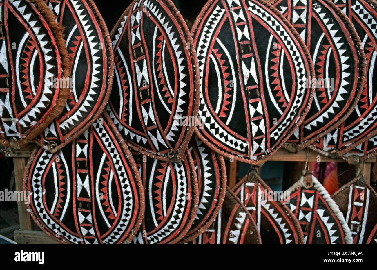 Selezione dei Masai scudi fatta da nascondere e dipinta con motivi geometrici venduti come souvenir su un mercato in stallo in Tanzania Foto Stock