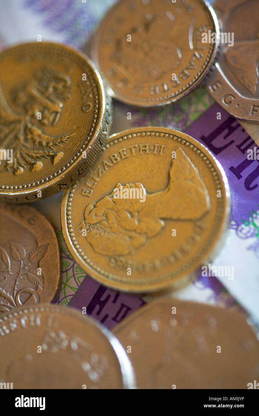 Assortimento di monete in inglese su venti pound note Foto Stock