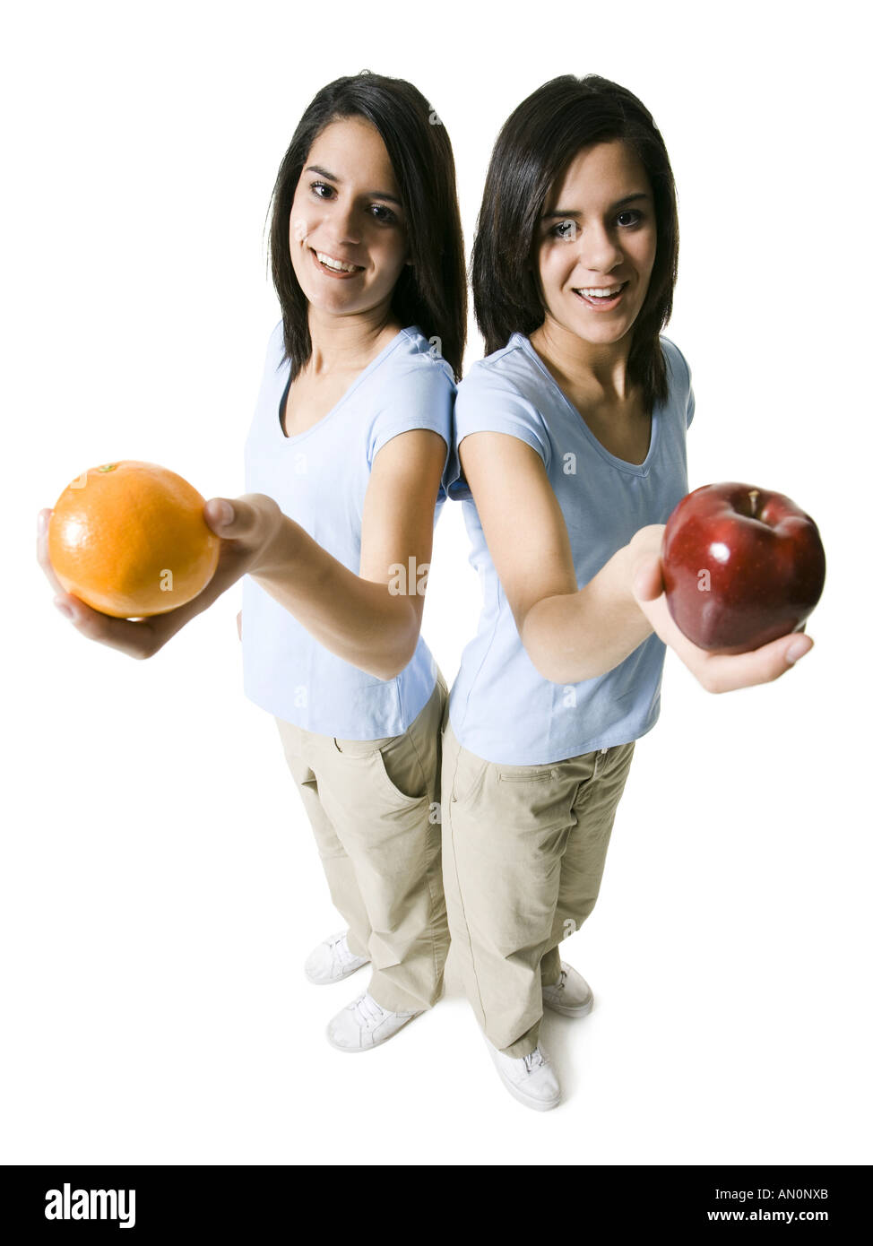 Angolo di alta vista di due ragazze adolescenti in possesso di un Apple e un'arancia Foto Stock
