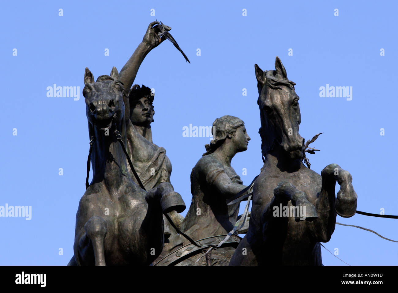 Statua romana di uomo, donna, cavalli e carri contro il cielo blu Foto Stock