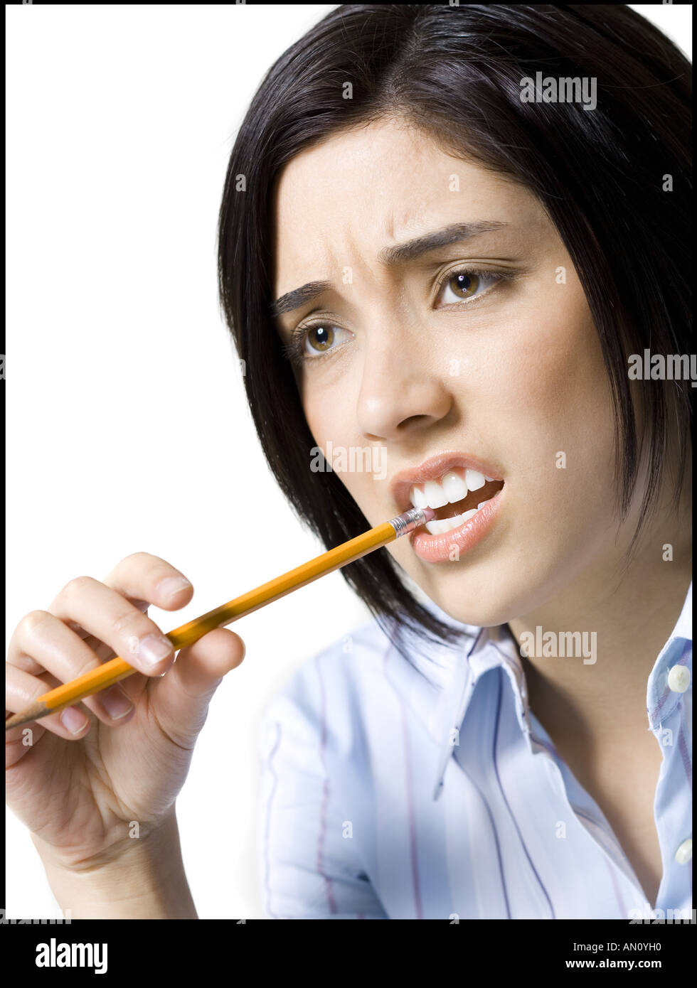 In prossimità di una giovane donna di mordere una matita Foto Stock
