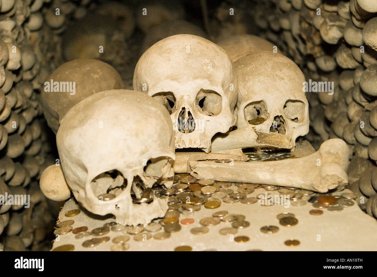 Teschi e le ossa e le monete in euro in un osso chiesa in Kutna Hora, Repubblica Ceca Foto Stock
