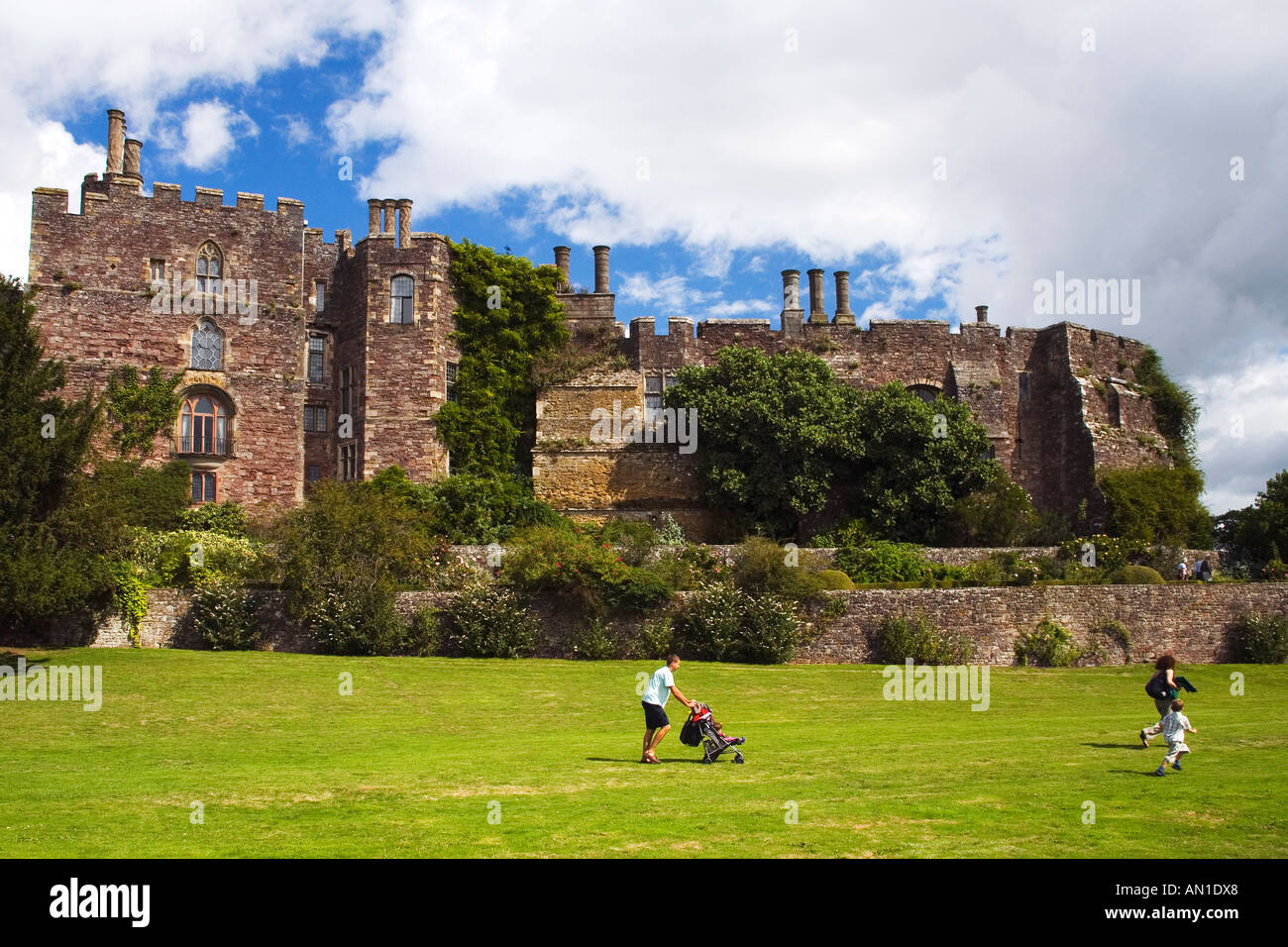 Berkeley castello normanno con coppia giovane e passeggino nella motivazione in estate Glos Gloucestershire England Regno Unito Regno Unito G Foto Stock