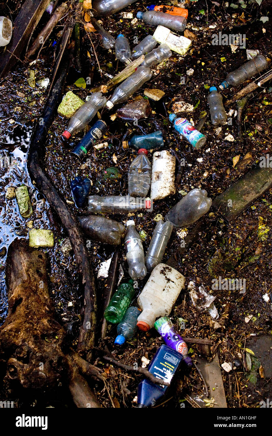 Le bottiglie di plastica e un assortimento di spazzatura giacciono in un flusso in Worcestershire città di Redditch Regno Unito Inghilterra scartato le bottiglie di plastica Foto Stock