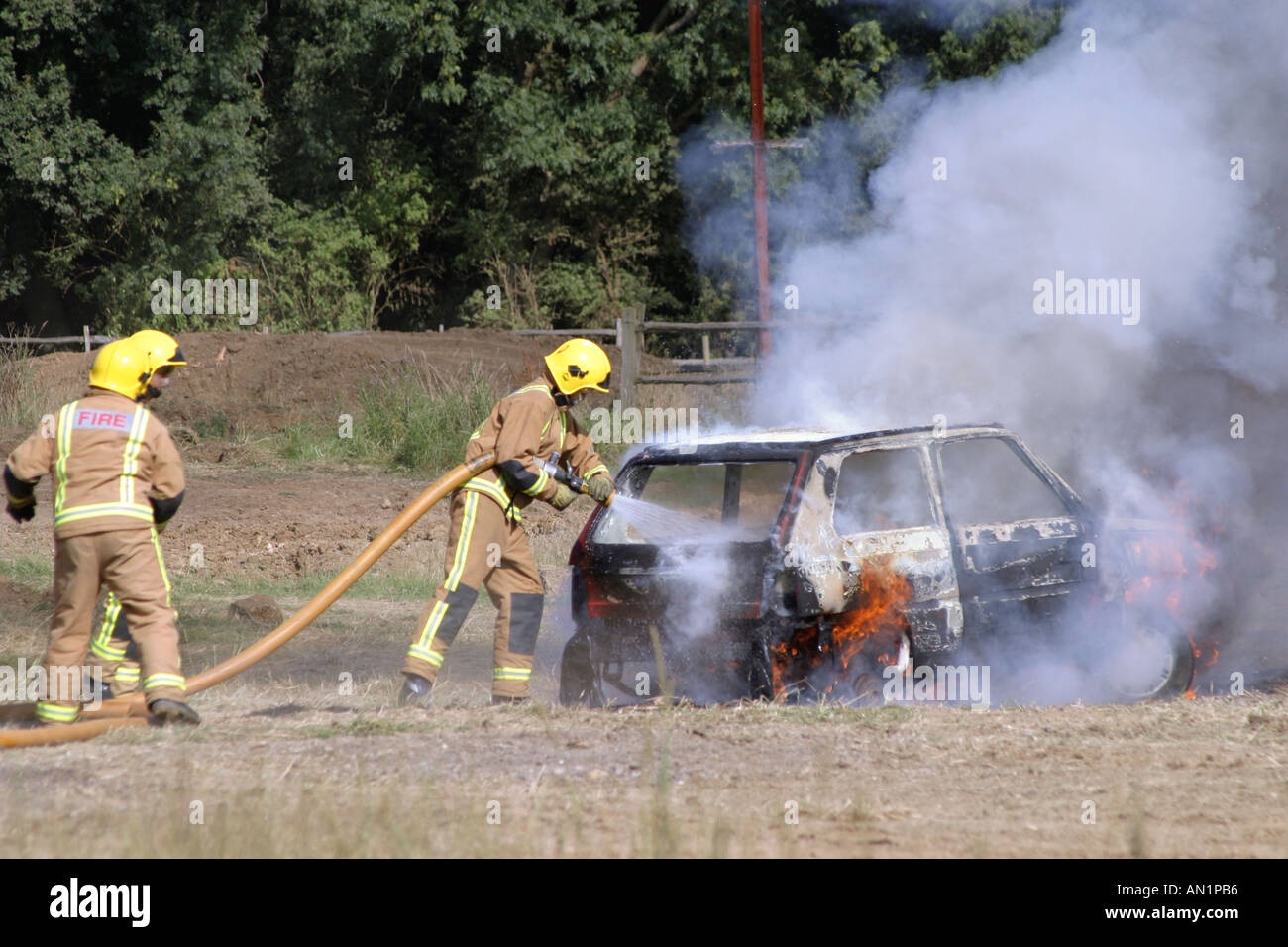 I vigili del fuoco che mettono fuori incendio sulla vettura Foto Stock