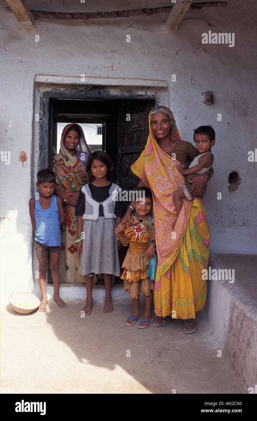 Famiglia amichevole dal Madhya Pradesh nei pressi di Khajuraho in piedi presso la porta alla loro casa rurale Foto Stock