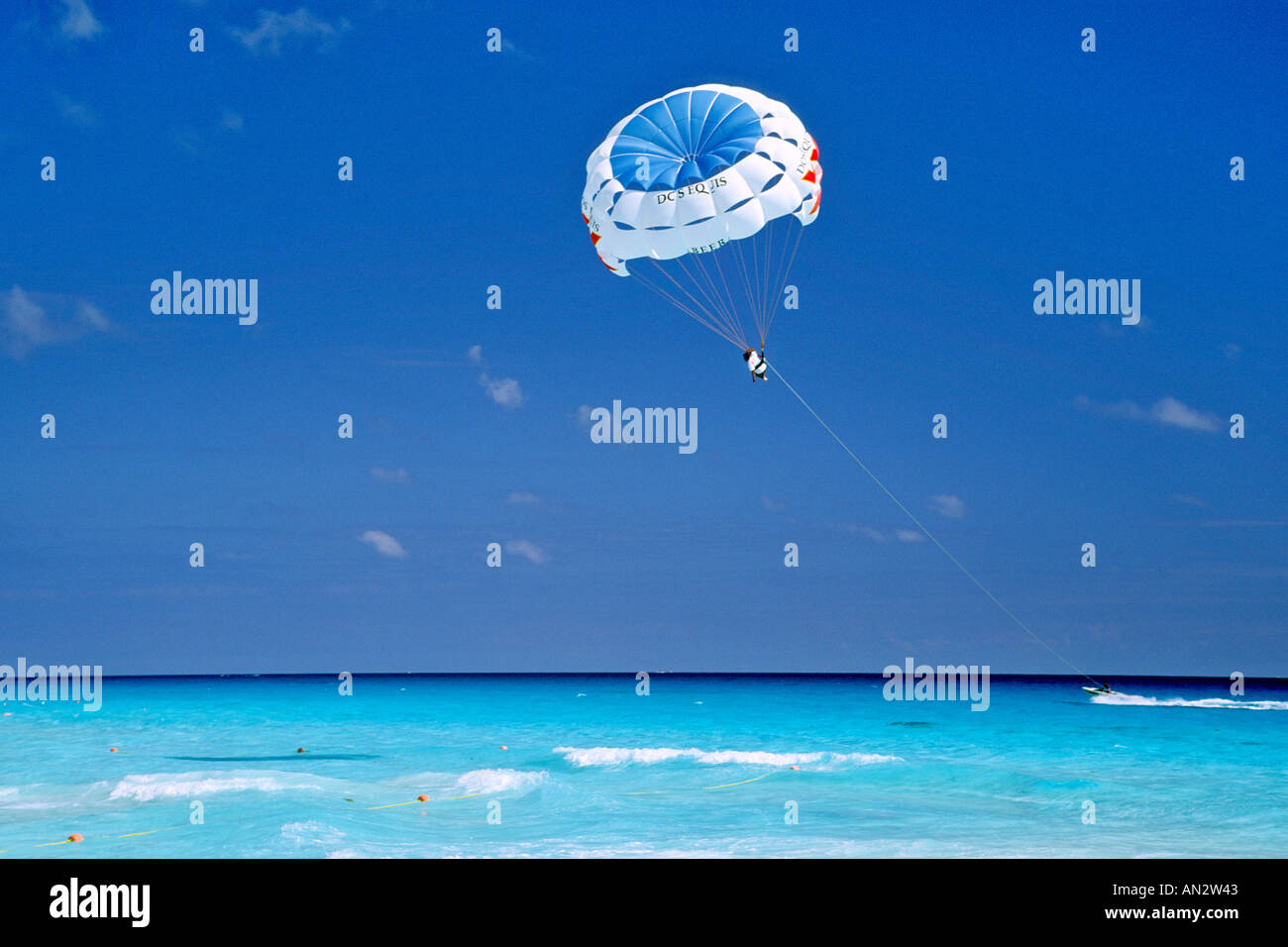 Un parasailer trainato da motoscafo al di sopra del mare dei Caraibi al largo della costa di Cancun in Messico. Foto Stock