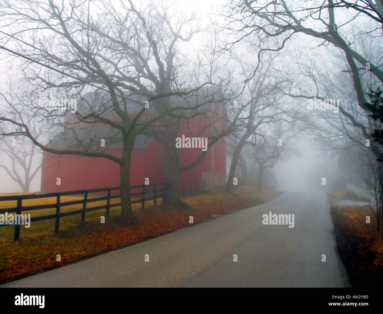 Foggy granaio rosso e Country Road Foto Stock