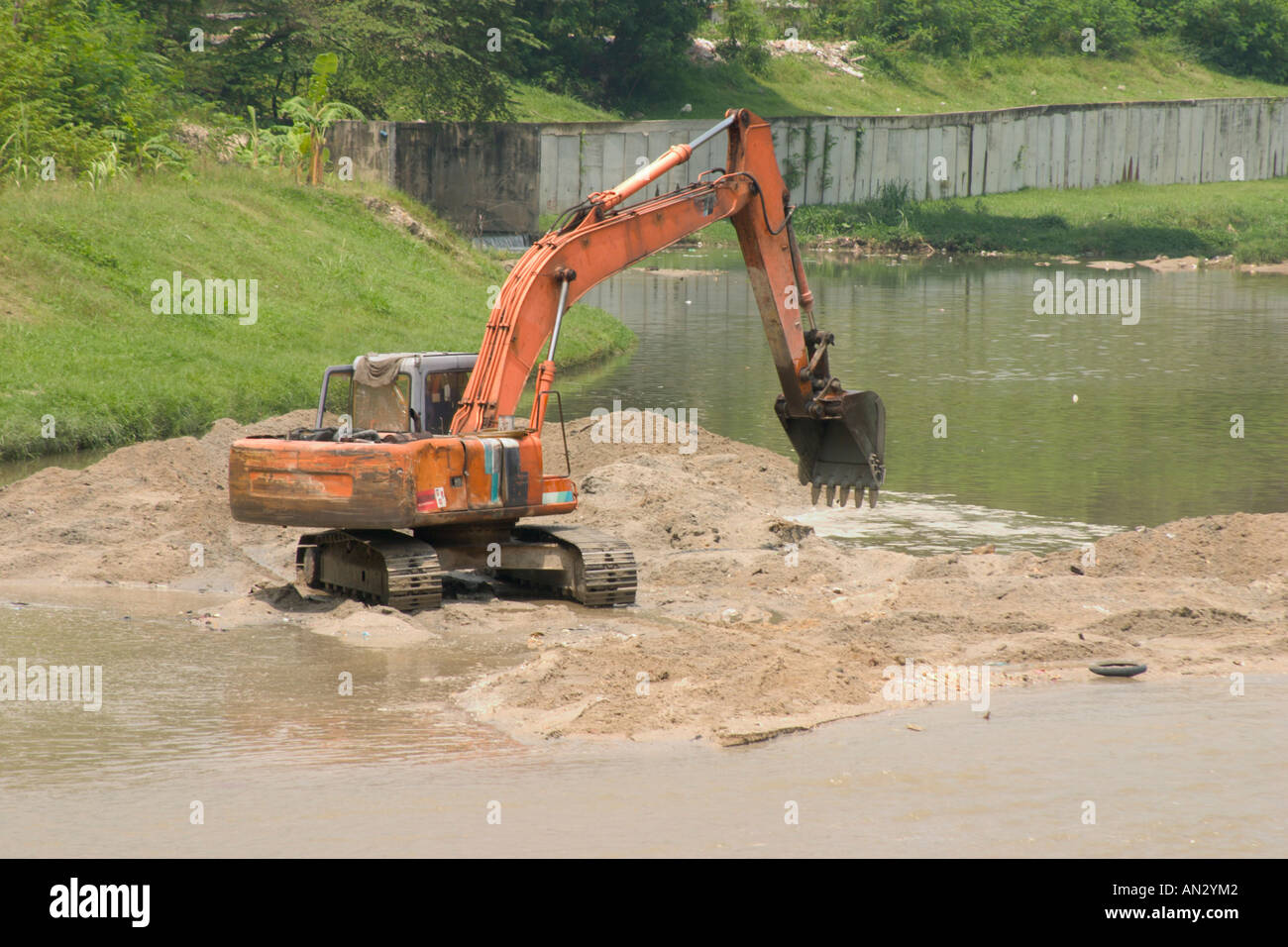 Escavatore cancellazione di sabbia da un fiume Foto Stock