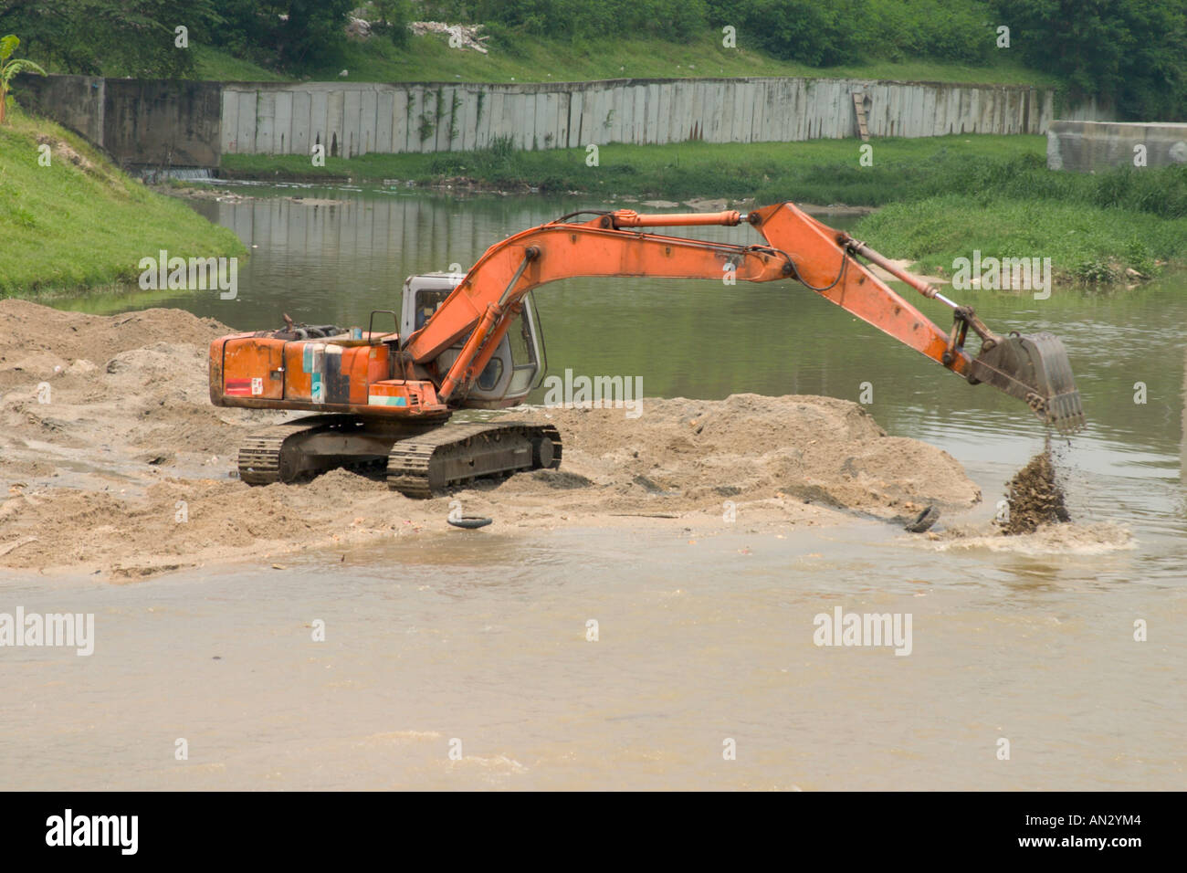 Escavatore cancellazione di sabbia da un fiume Foto Stock