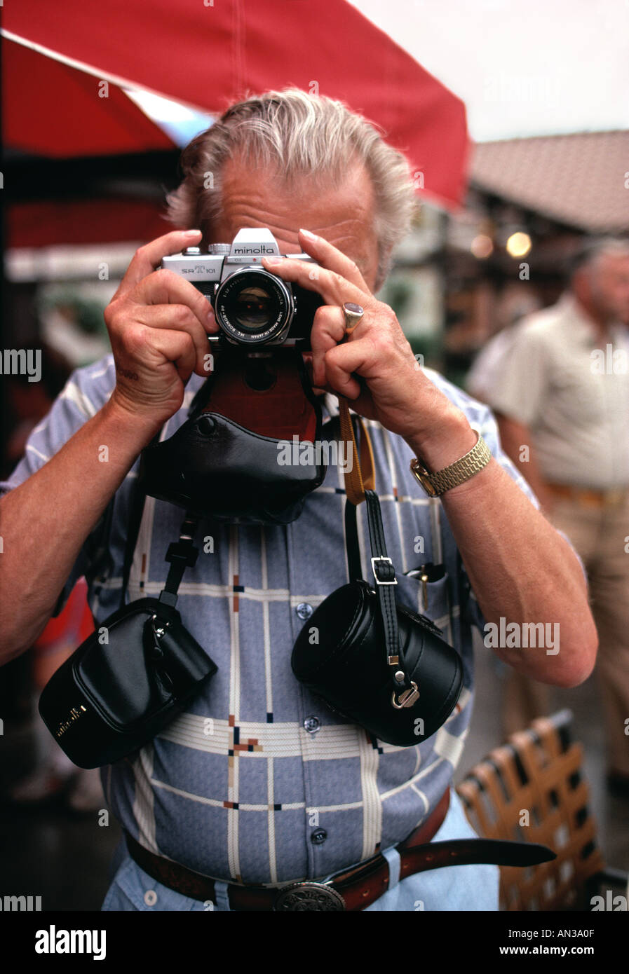 Senior fotografo amatoriale prendendo foto il trasporto di più casi della fotocamera Foto Stock