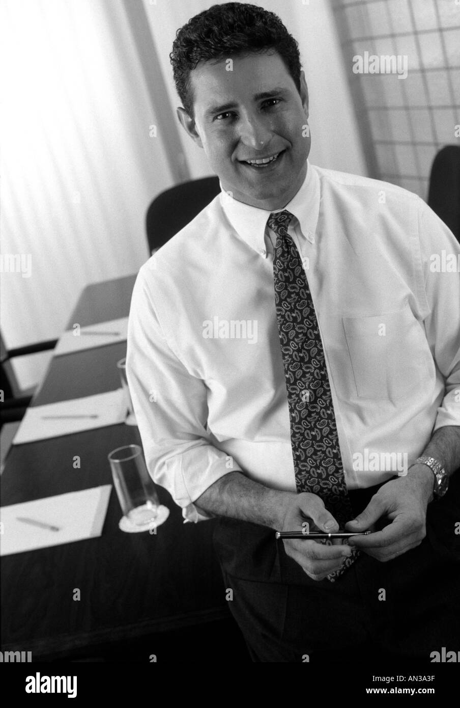 Ritratto in bianco e nero di executive in piedi di fronte a un tavolo per conferenza Foto Stock