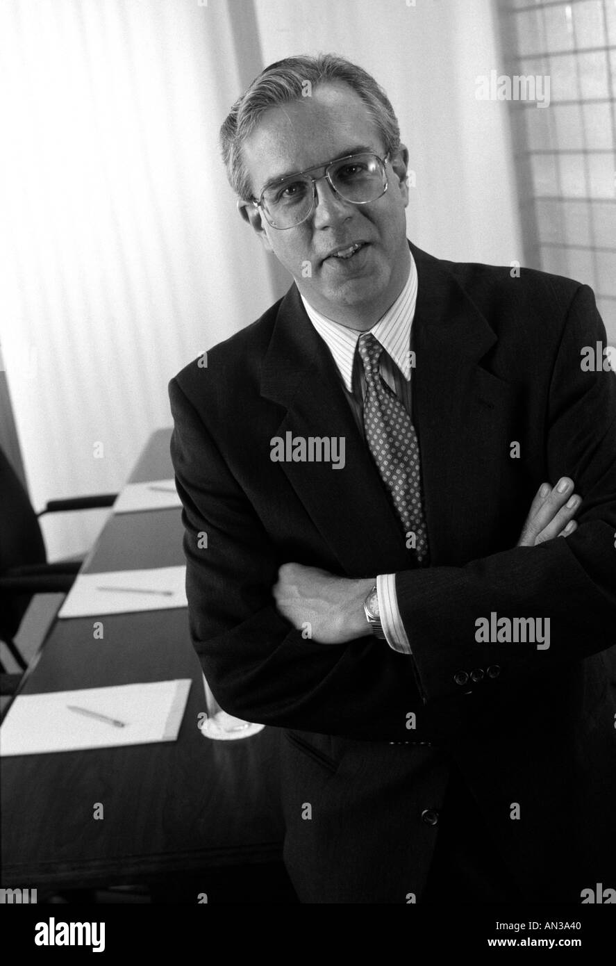 Ritratto in bianco e nero di executive in piedi di fronte a un tavolo per conferenza Foto Stock