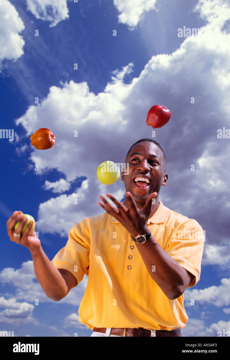 African American uomo juggling mele Foto Stock