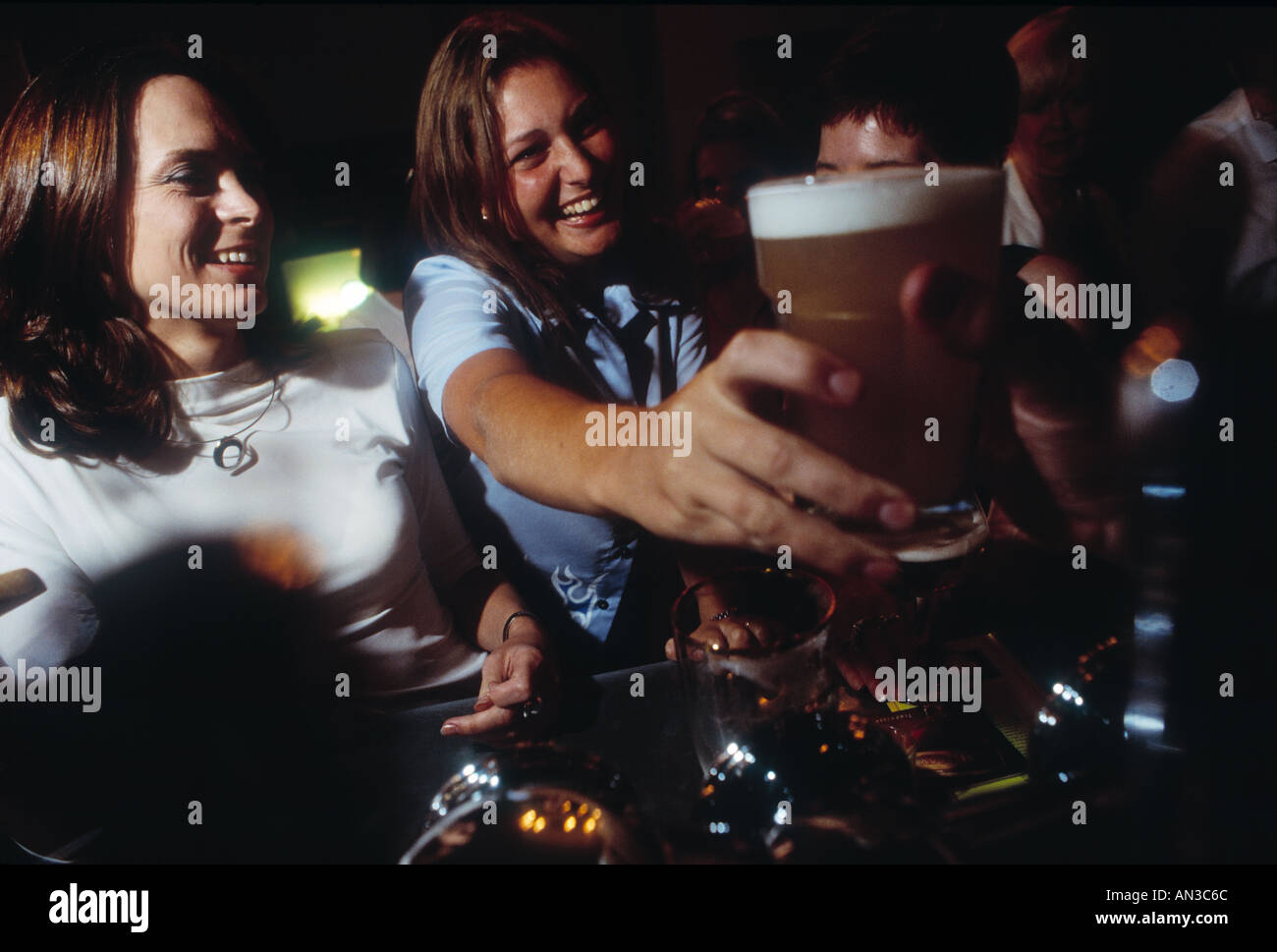 Felice ragazza ridere fuori con gli amici a bere birra e alcolici in città a Londra REGNO UNITO Inghilterra England Foto Stock