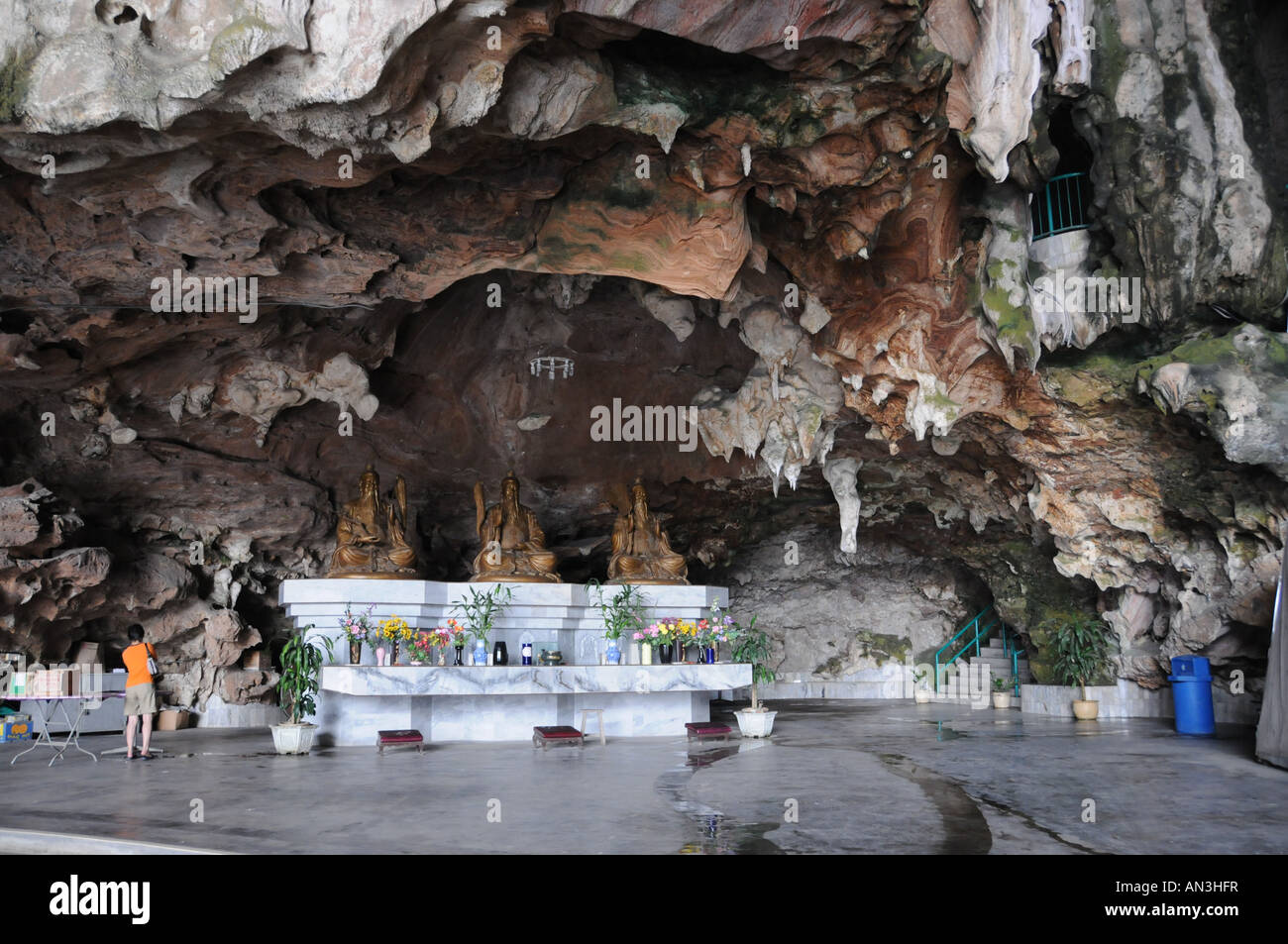 Un devoto una illuminazione joss stick per le sue preghiere in una grotta in Ipoh, Perak, Malaysia Foto Stock