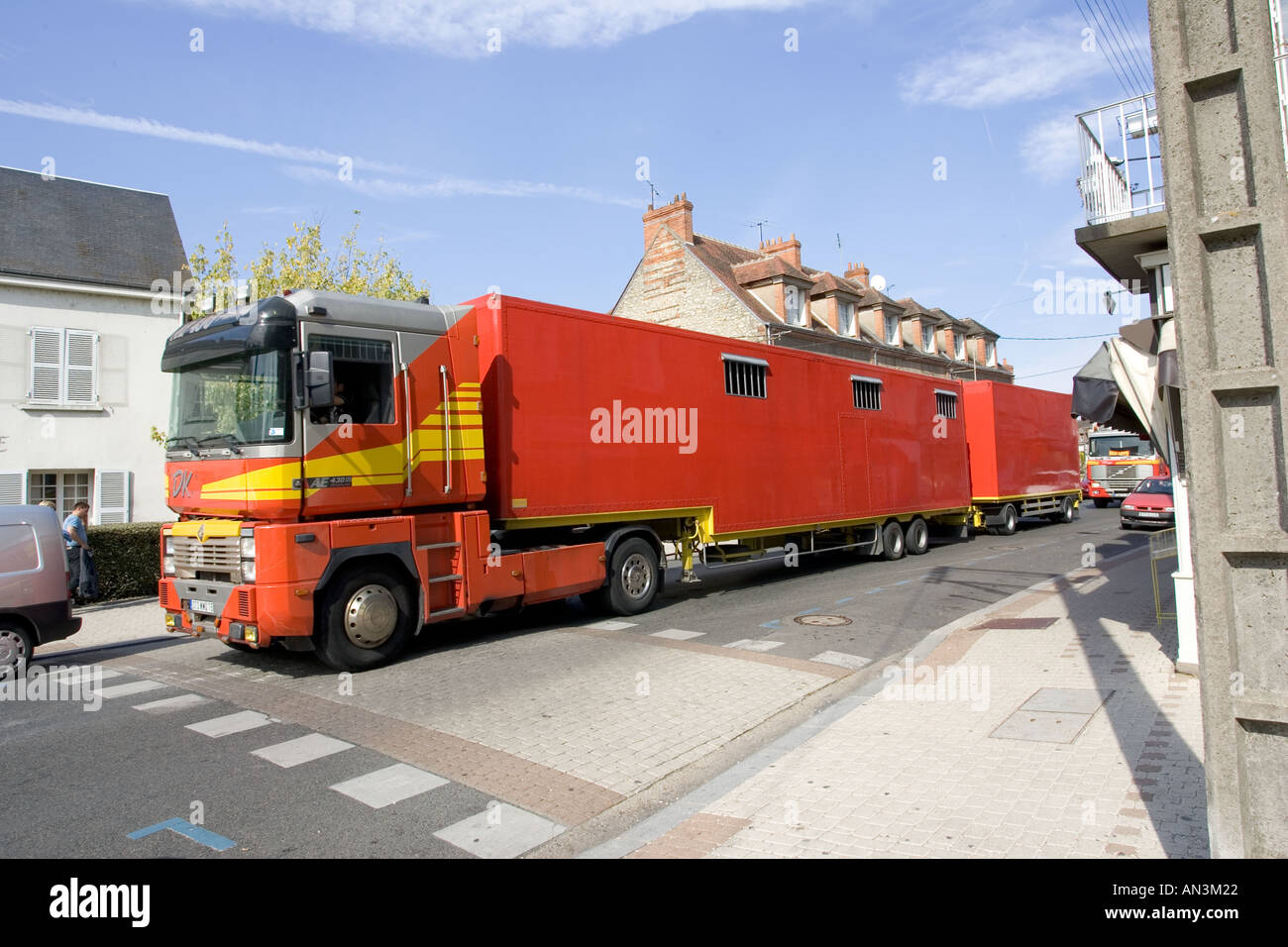 Grande Circo Rosso autocarri e rimorchi bloccando il traffico in strade strette di Chateauneuf sur Loire Francia Foto Stock