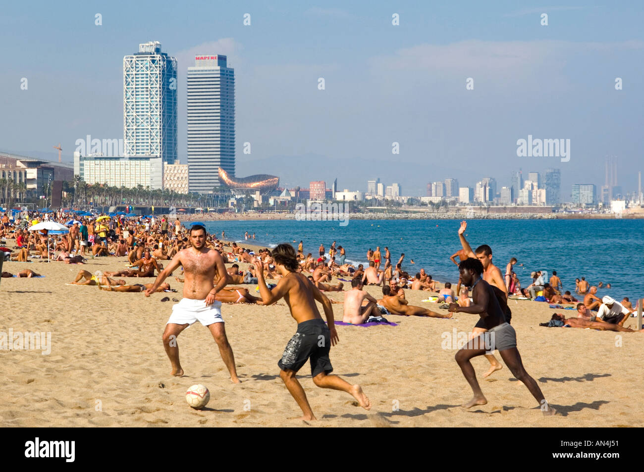 Le persone che giocano a calcio sulla spiaggia di Platja Barceloneta Barcellona Spagna Foto Stock