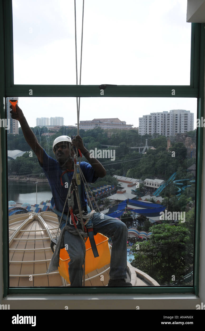 Vista di un contratto operaio pulizia di Windows a un complesso di shopping in Sunway Lagoon, Malaysia Foto Stock