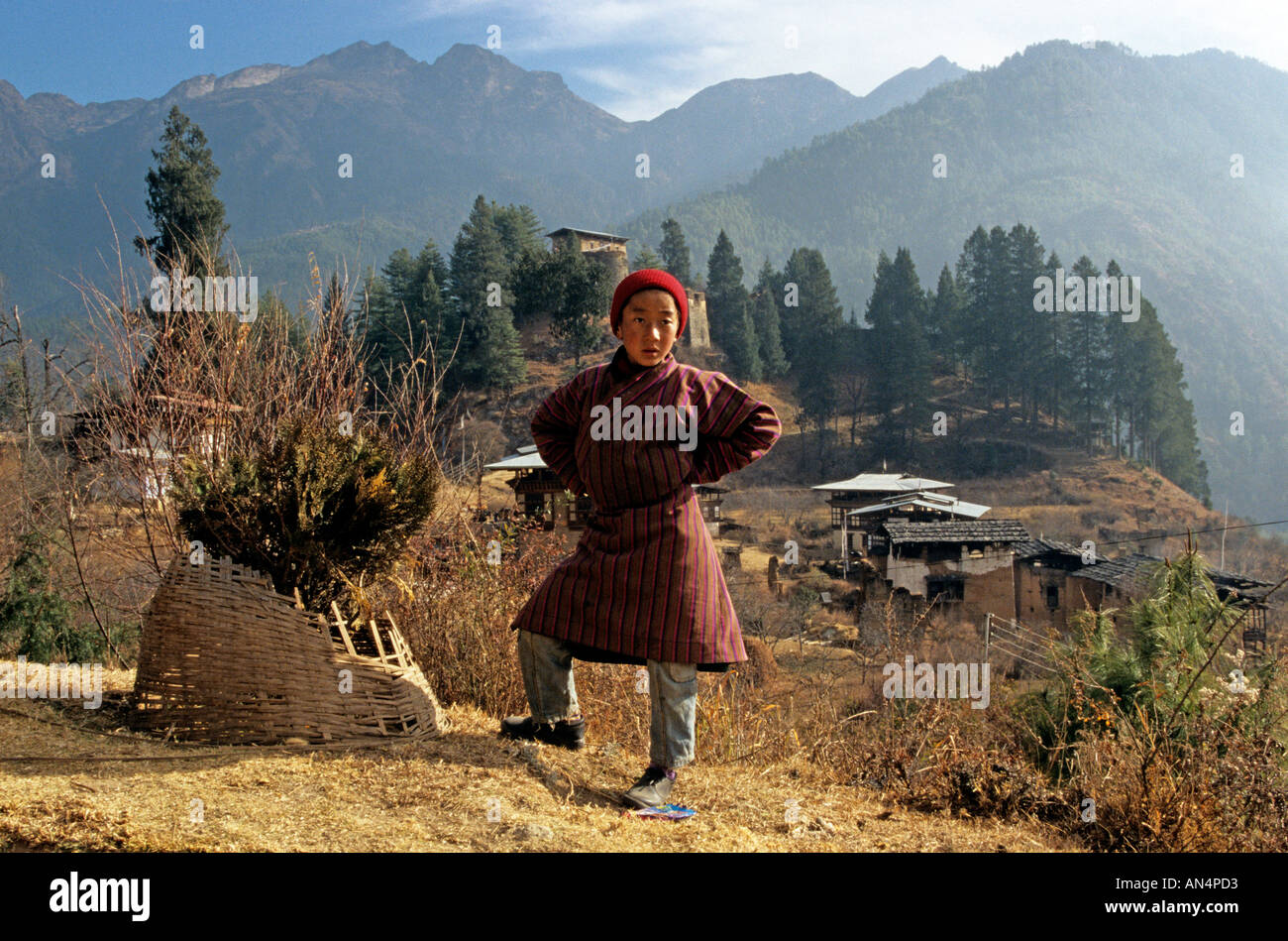 Ragazzo che indossa abiti tradizionali in posa di paesaggio di montagna, ritratto, Bhutan, Asia del Sud Foto Stock