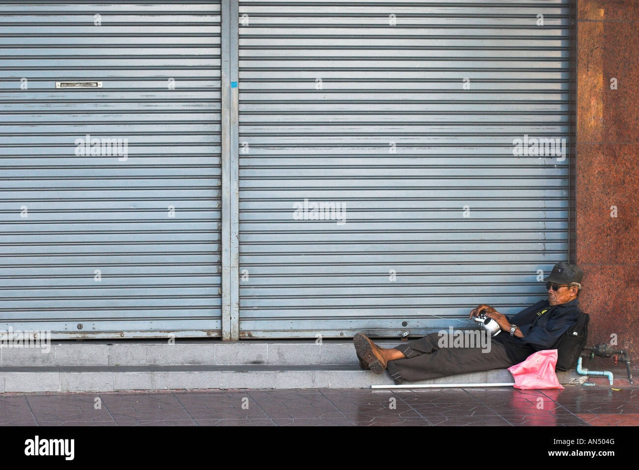 Il vecchio uomo dormire per strada di Bangkok Foto Stock