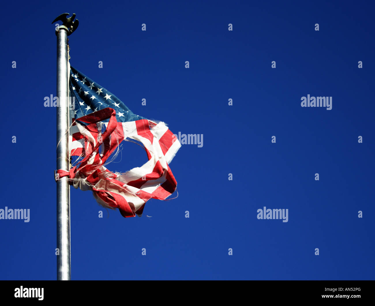 In prossimità di una bandiera americana che è stato strappato lacerato e piena di buche ma ancora sventolare Foto Stock