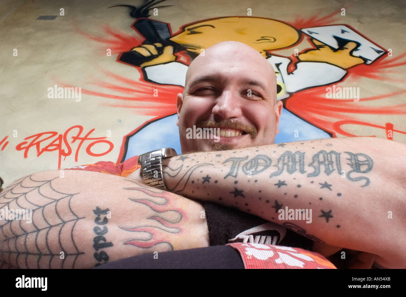 Bald biker con tattoo e grandi bracci sorridente Foto Stock