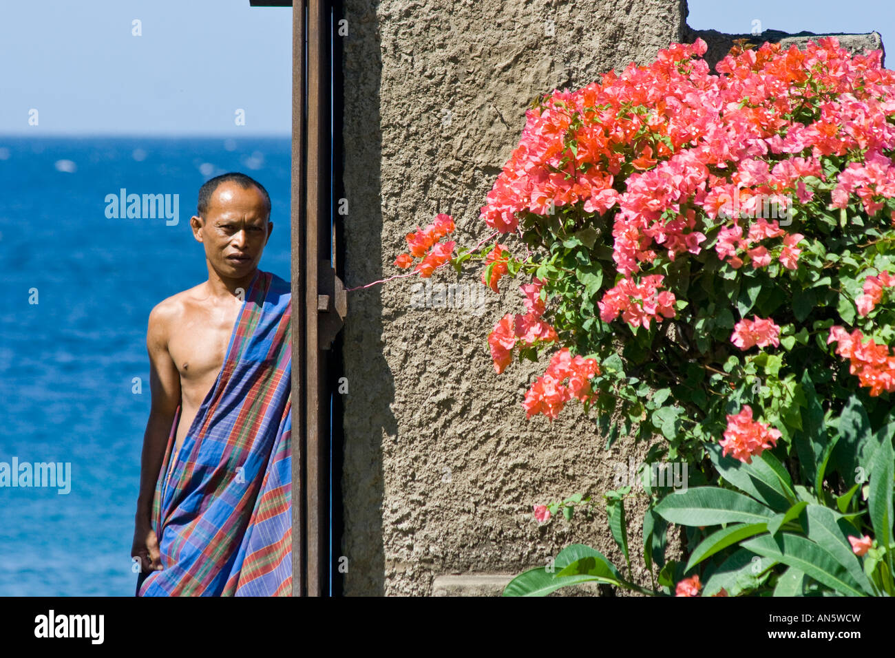 Uomo Balinese in Sarong sulla Spiaggia di Amed Bali Indonesia Foto Stock