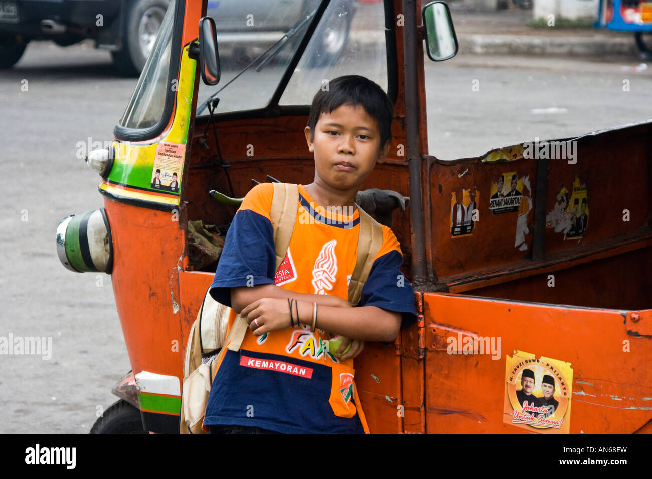 Ragazzo appoggiato su un Tuk Tuk Jakarta Indonesia Foto Stock