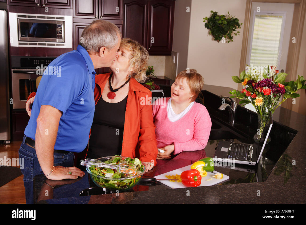 Guardare la ragazza giovane kissing in cucina Foto Stock