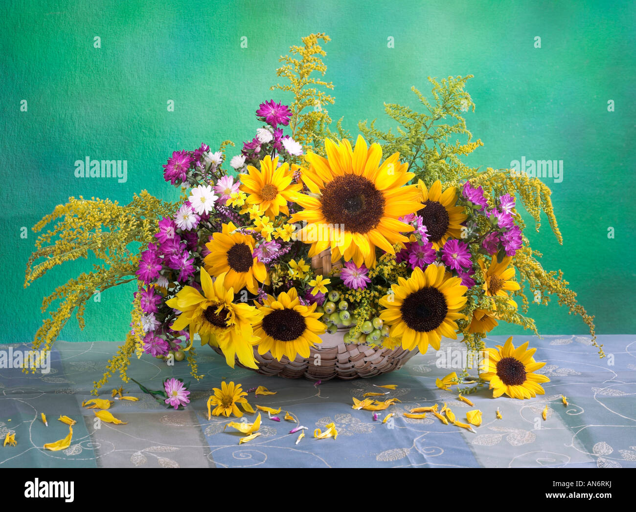 Studio disposti mazzetto giallo bouquet di girasoli in un cesto su un verde sfondo pastello Foto Stock