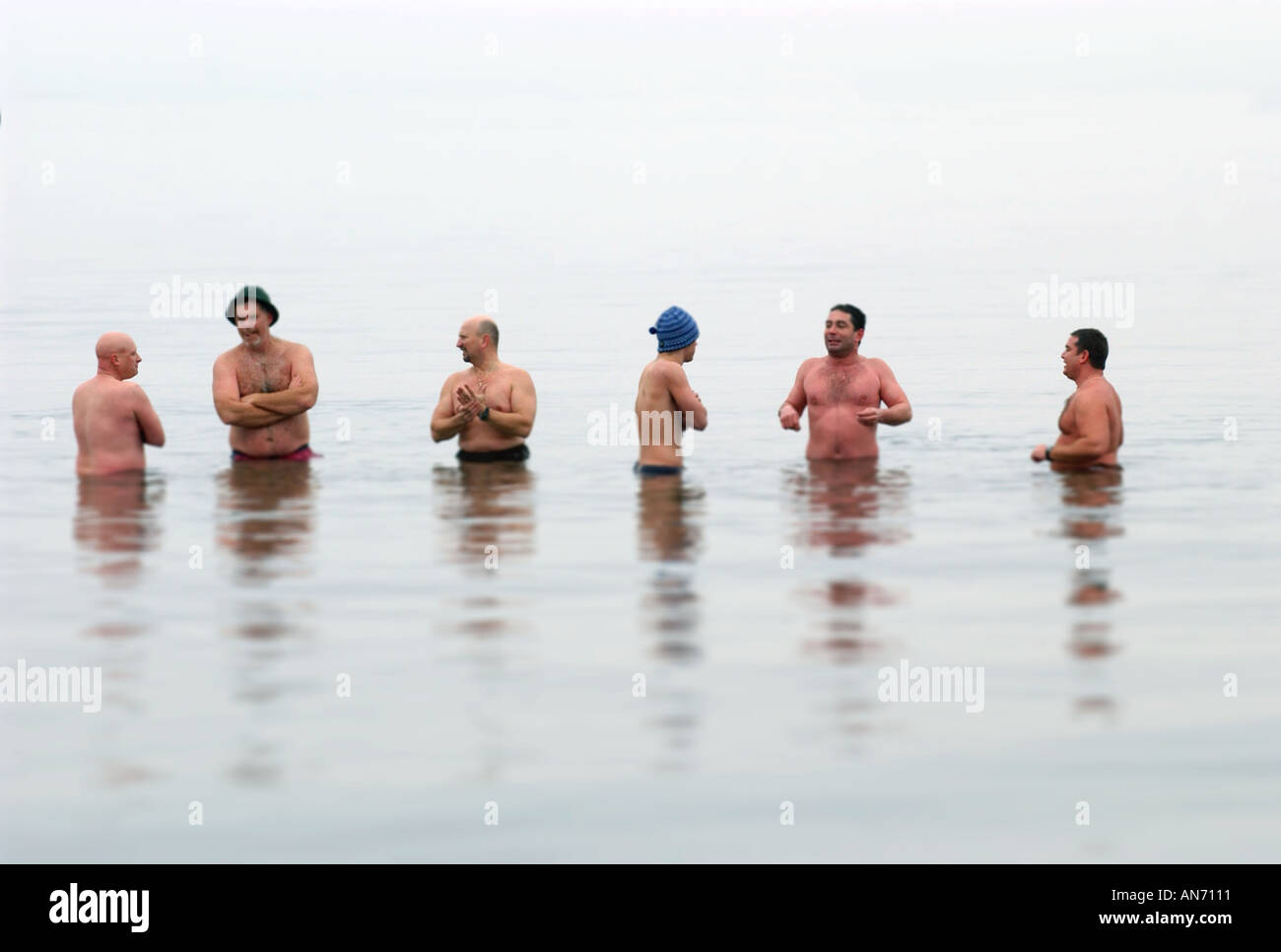 Una fila di uomini in acqua gelida Foto Stock