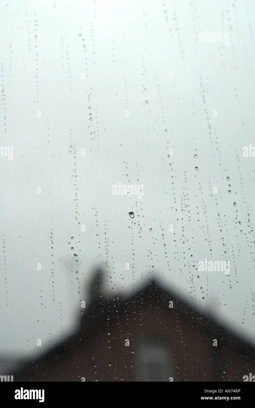 Gocce di pioggia sulla finestra di casa vista dall'interno Foto Stock