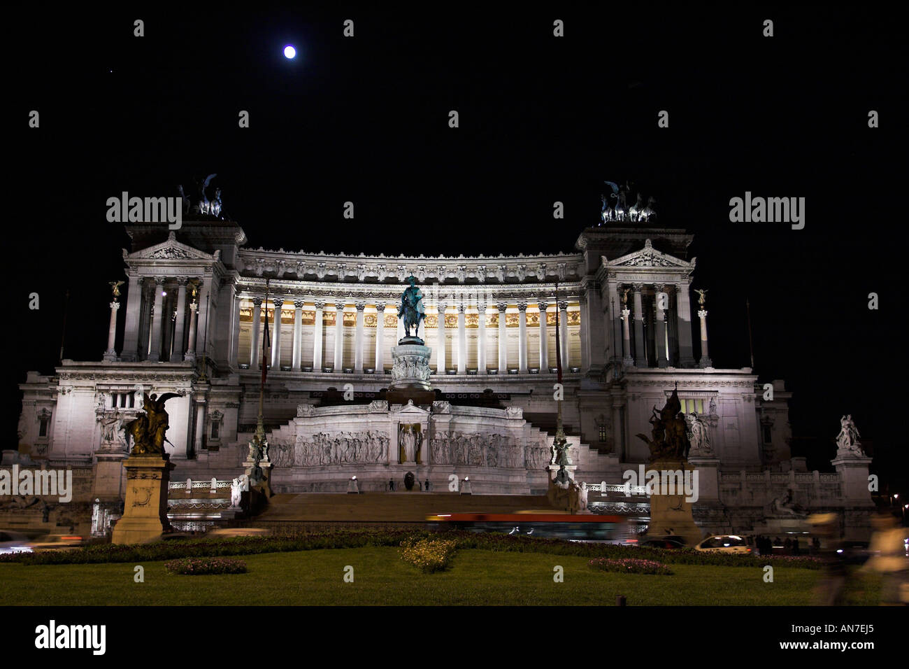 La luna piena splende sopra i campi illuminati da Monumento a Vittorio Emanuele o Torta di Nozze monumento Foto Stock