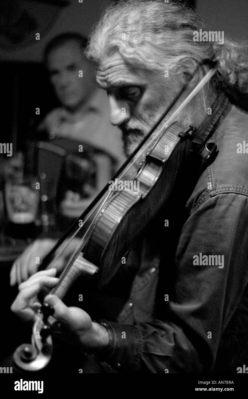 Melodie celtiche un pony tailed fiddle player in un tradizionale pub Irlandese Foto Stock
