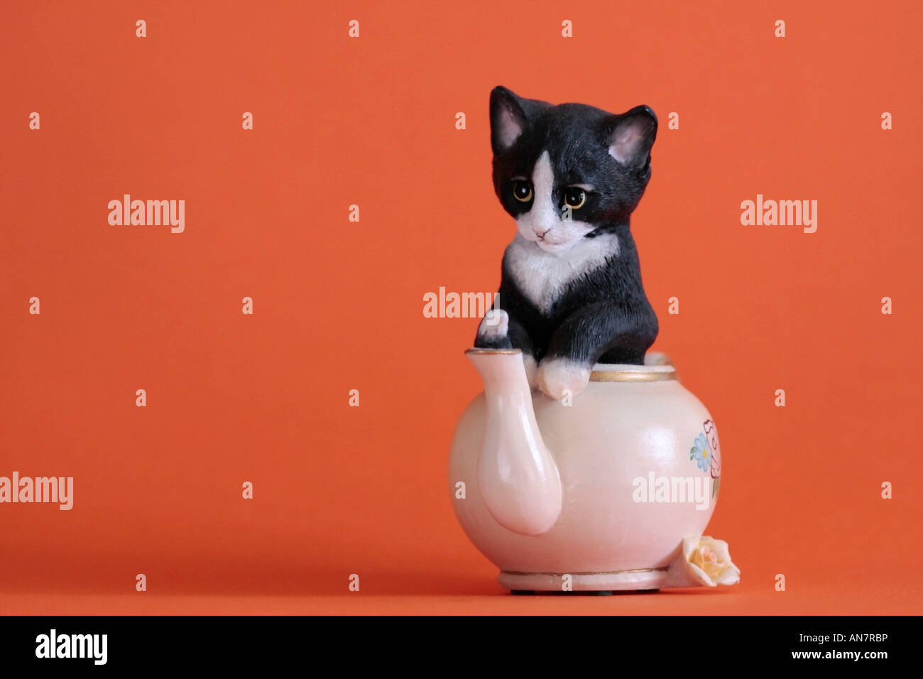 Modello di ceramica di gattino in una teiera con coda sporgente del tubo di lancio Foto Stock